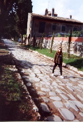 Bettina Drummond strolling along a portion of the Via Appia, an example of the Roman network of roads that spanned from one end of the empire to the other.