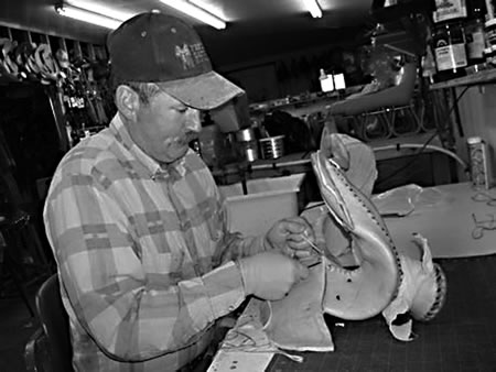 After carving, shaping and treating all the parts, the saddle is draped in rawhide which is ultimately trimmed and stitched to the saddle. 