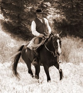 Jim on an American Warmblood Esprit moving through the sagebrush. Esprit is an FEI Level competition dressage horse.