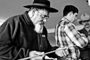 Armando Deferrari studies a work in progress as students continue to braid.